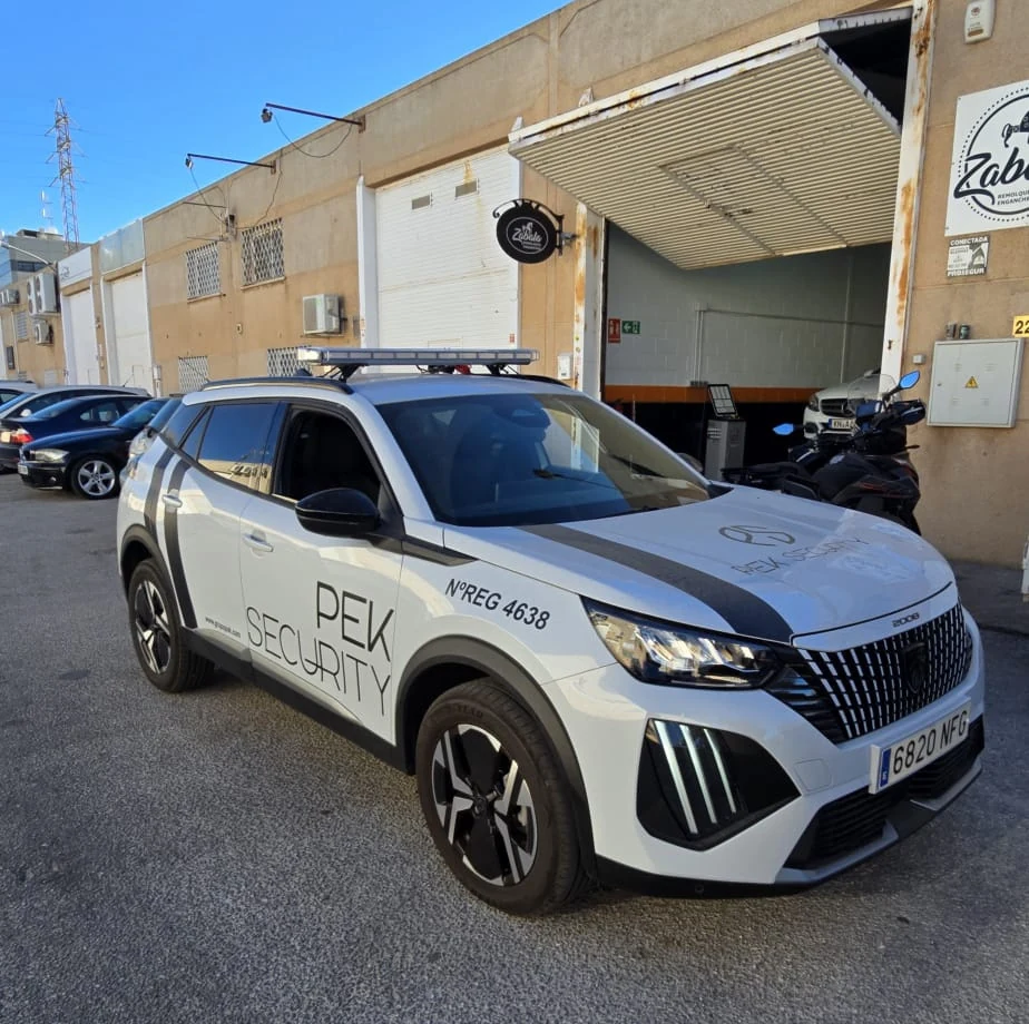 Vehículo de patrulla real rotulado PEK SECURITY estacionado en un entorno industrial de Málaga